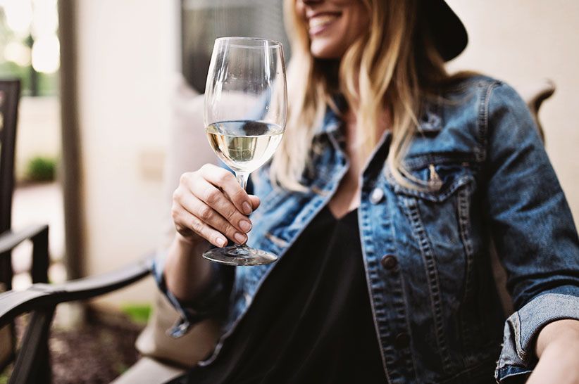 a woman holding a sauvignon blanc wine