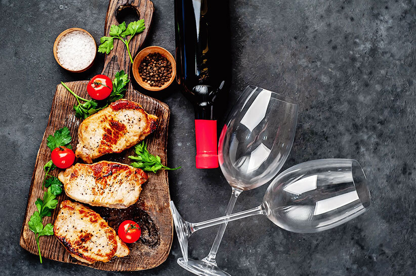 grilled pork steaks with bottle of chardonnay wine